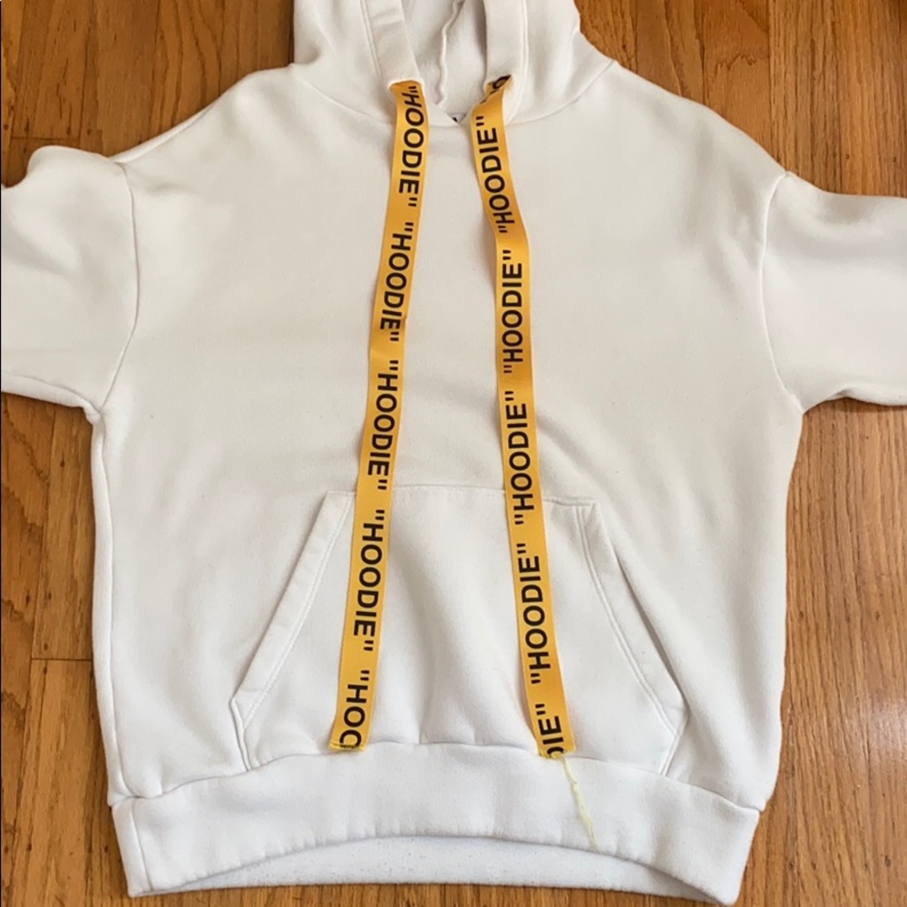 White hoodie with “hoodie” on the strings